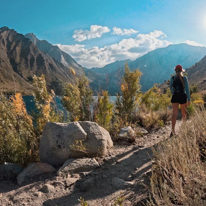 Woman looking over cliff at a scenic hiking spot in Mammoth Lakes, CA.