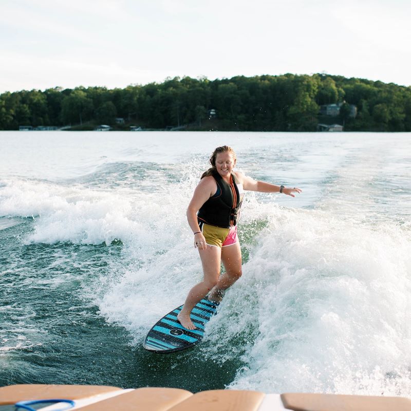 woman having fun wake surfing on the lake