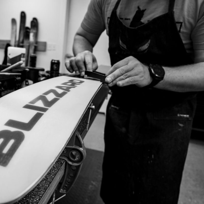 Ski tech waxing skis and tunning skis at the Sun & Ski Sports ski and snowboard shop. 