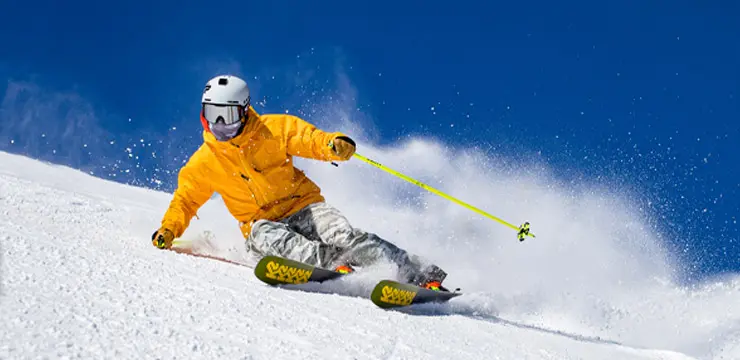 Skier skiing downhill on groomers during resort opening 