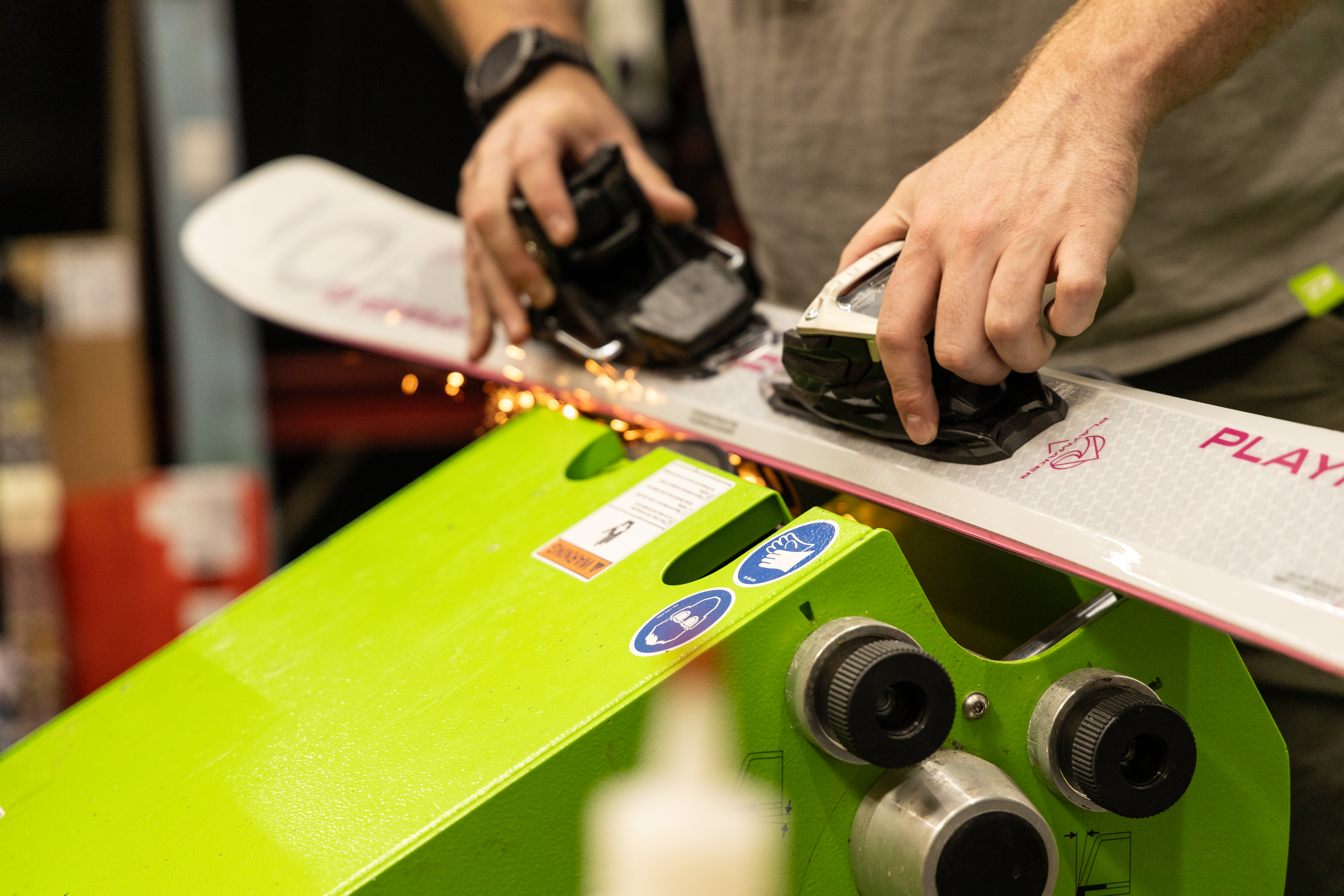 Man sharpening the edge of skis which is a ski tuning service performed at sun & Ski Sports.