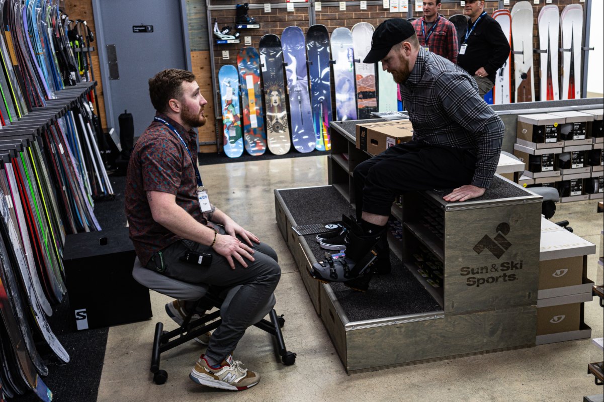 An Outdoor Expert helping a customer with their snowboarding boots