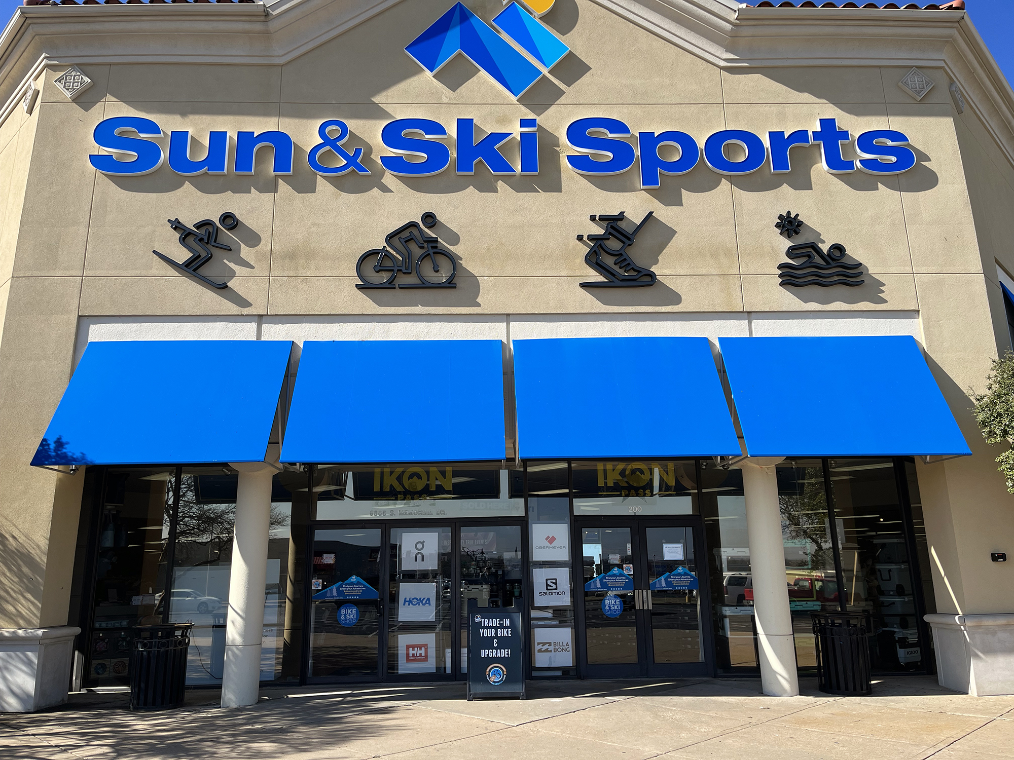 Wall of skis and ski boots at a Sun & Ski Sports shop in Phoenix, Arizona.