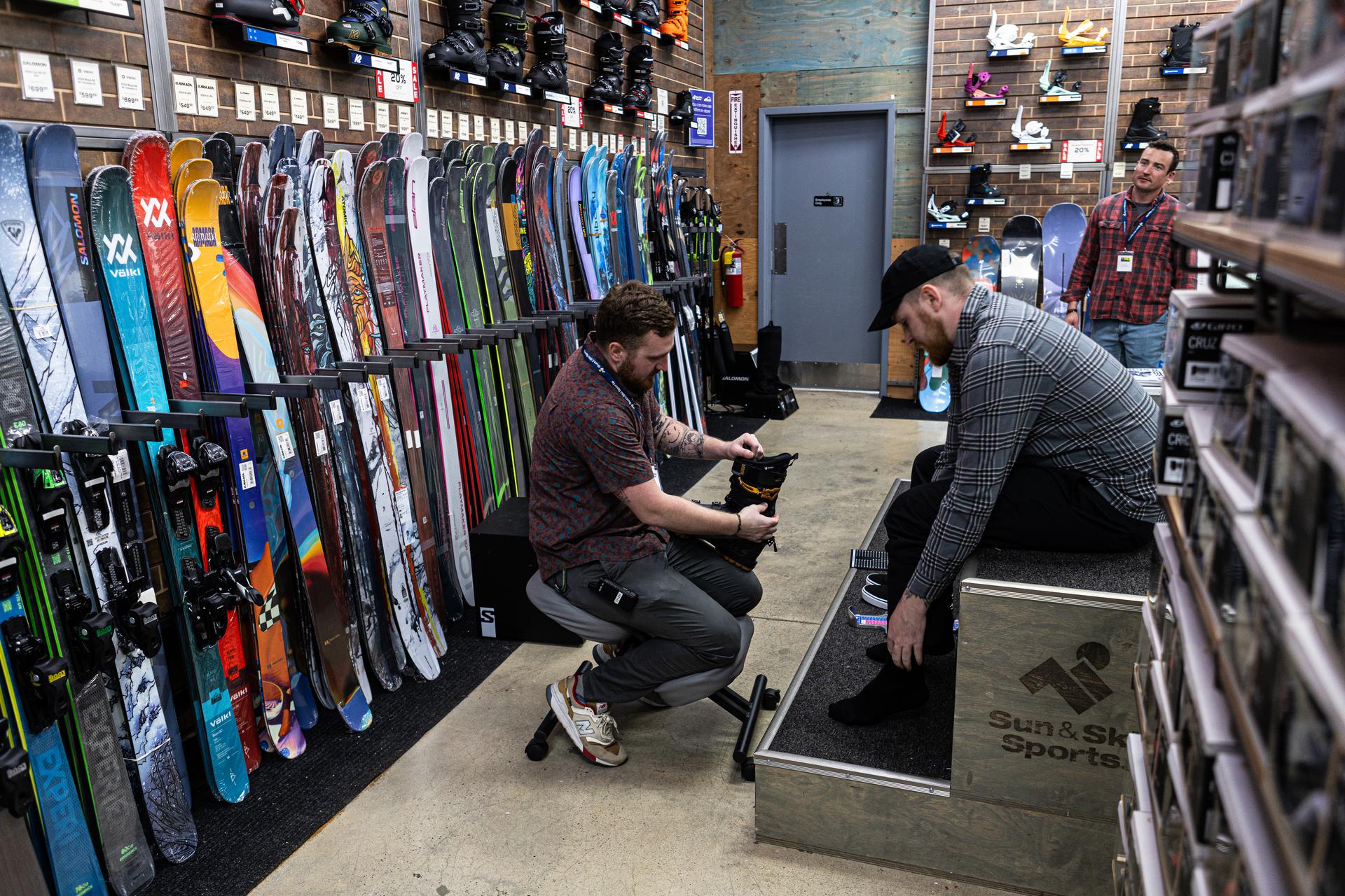 Sun & Ski Sports outdoor expert helping a customer with ski boot fitting services
