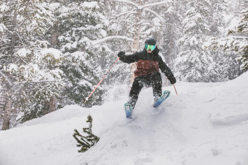 Action shot of a skier in Sun & Ski Sports ski winter gear