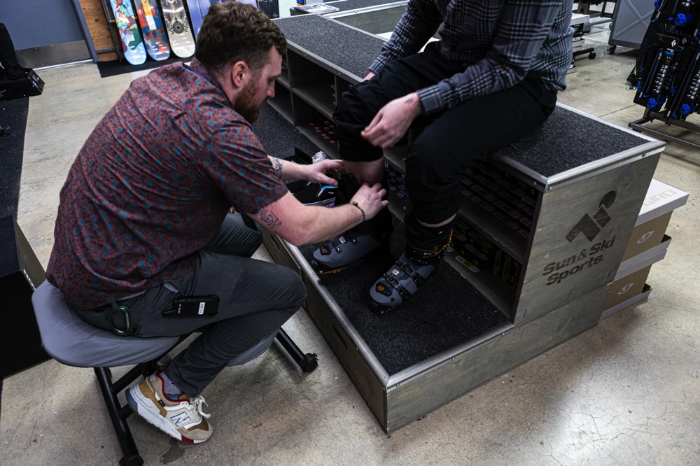 Outdoor Expert helping a Katy customer get the right size ski boots.