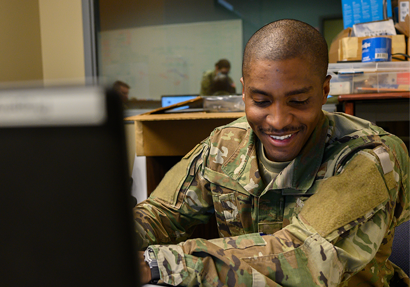 Man with headset, smiling, working at table