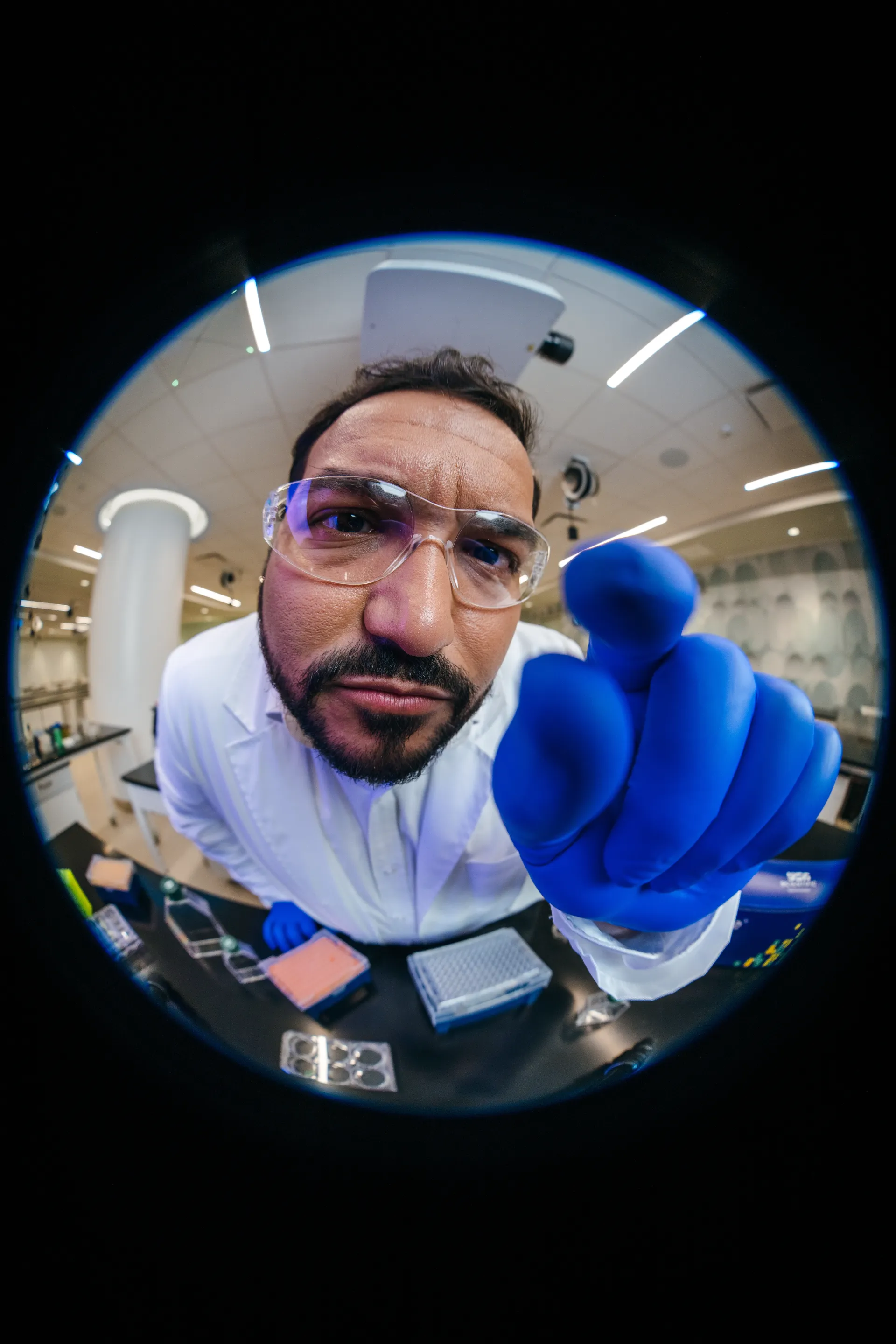 Scientist pointing toward the camera under circular lens framing