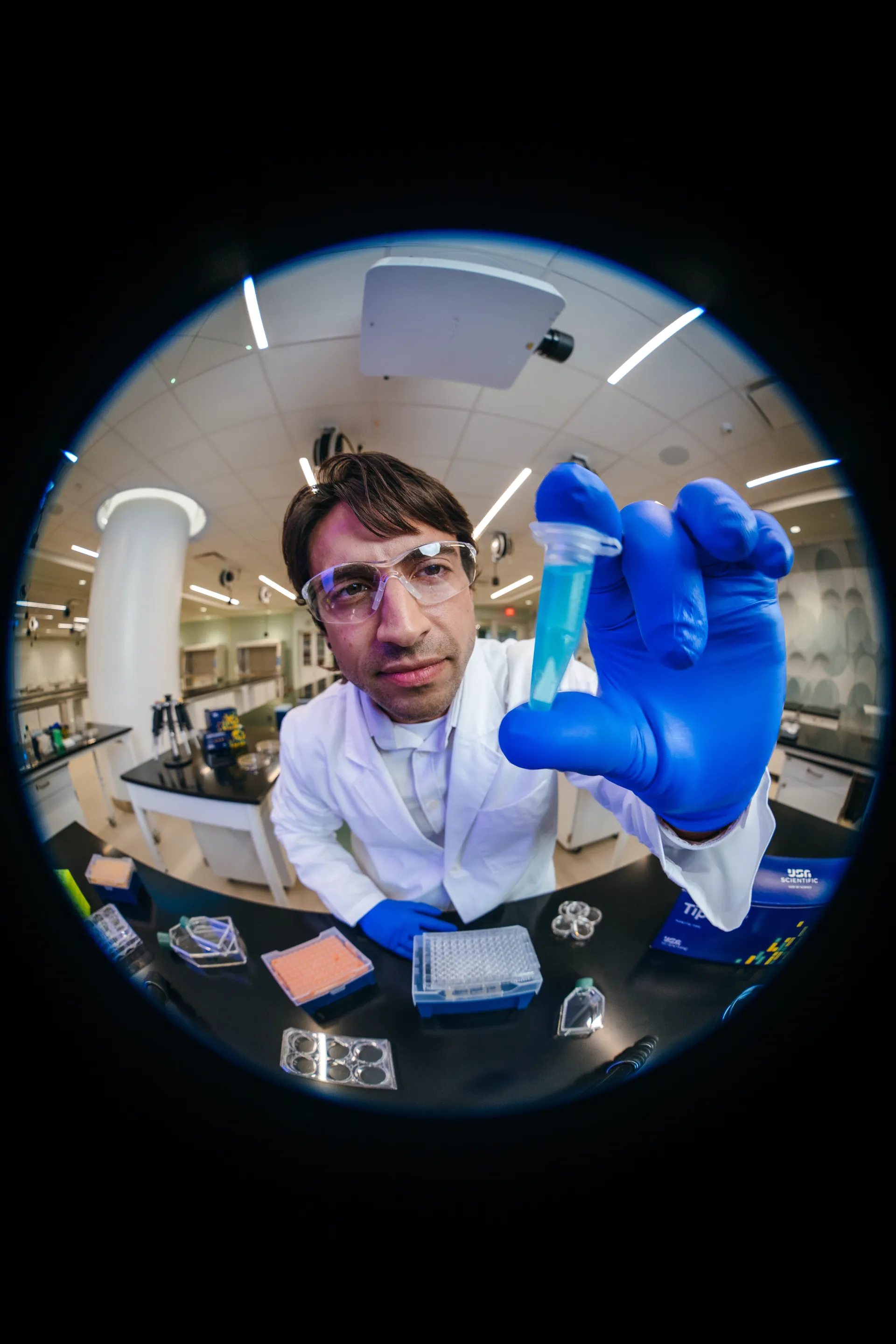Scientist holding a sample tube toward the camera